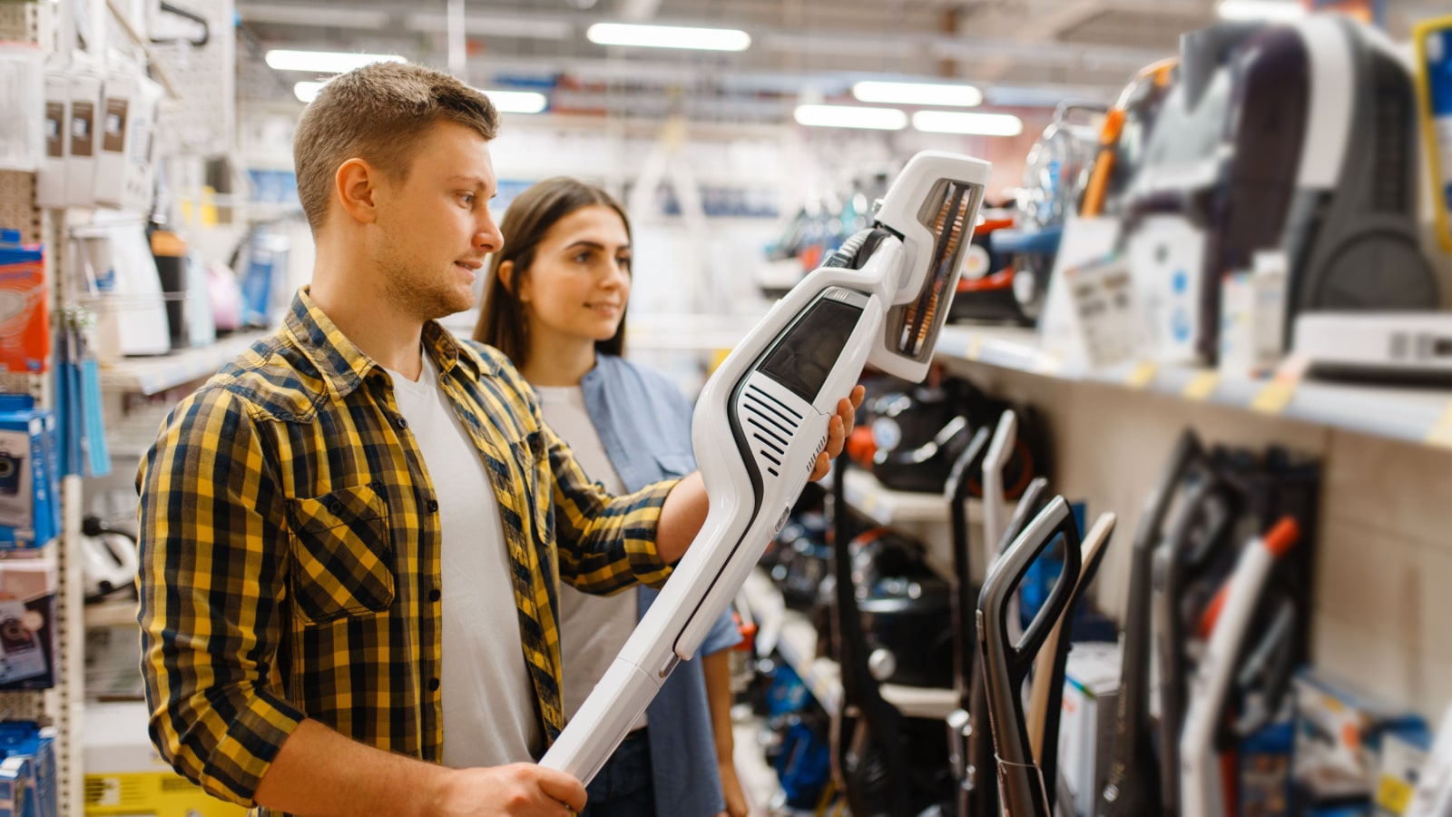 A couple shopping for vacuum cleaners.