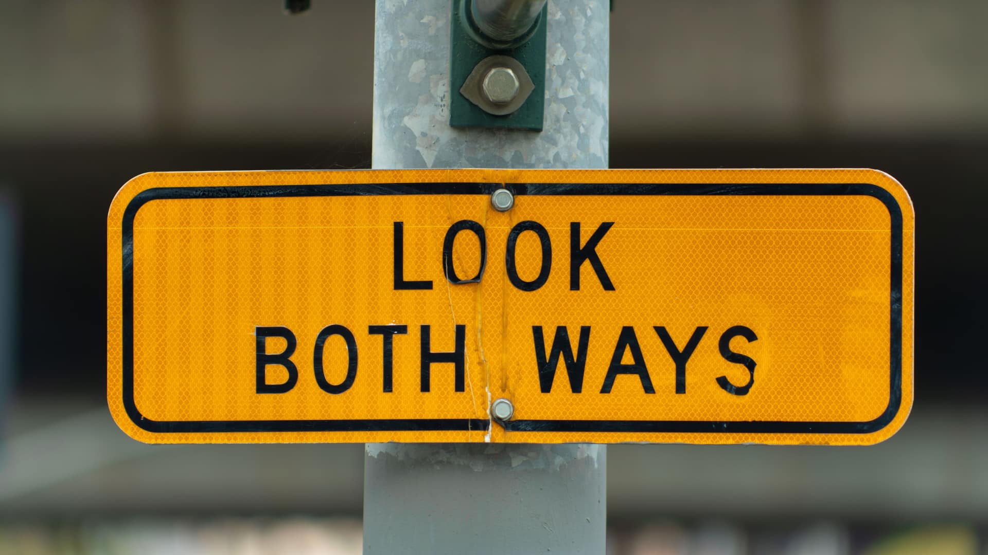 A yellow road sign that says "look both ways"