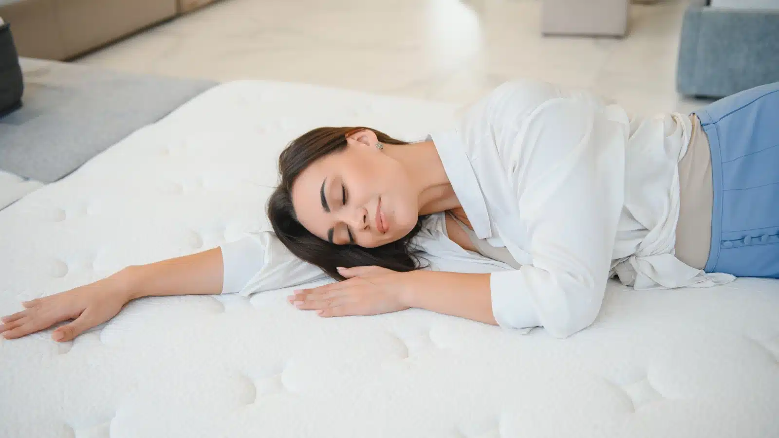 A woman testing out a mattress at the store. A great mattress can help you sleep better. 