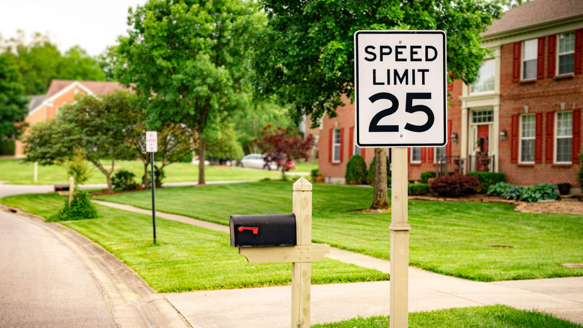 A 25 MPH speed limit sign in a residential neighborhood.