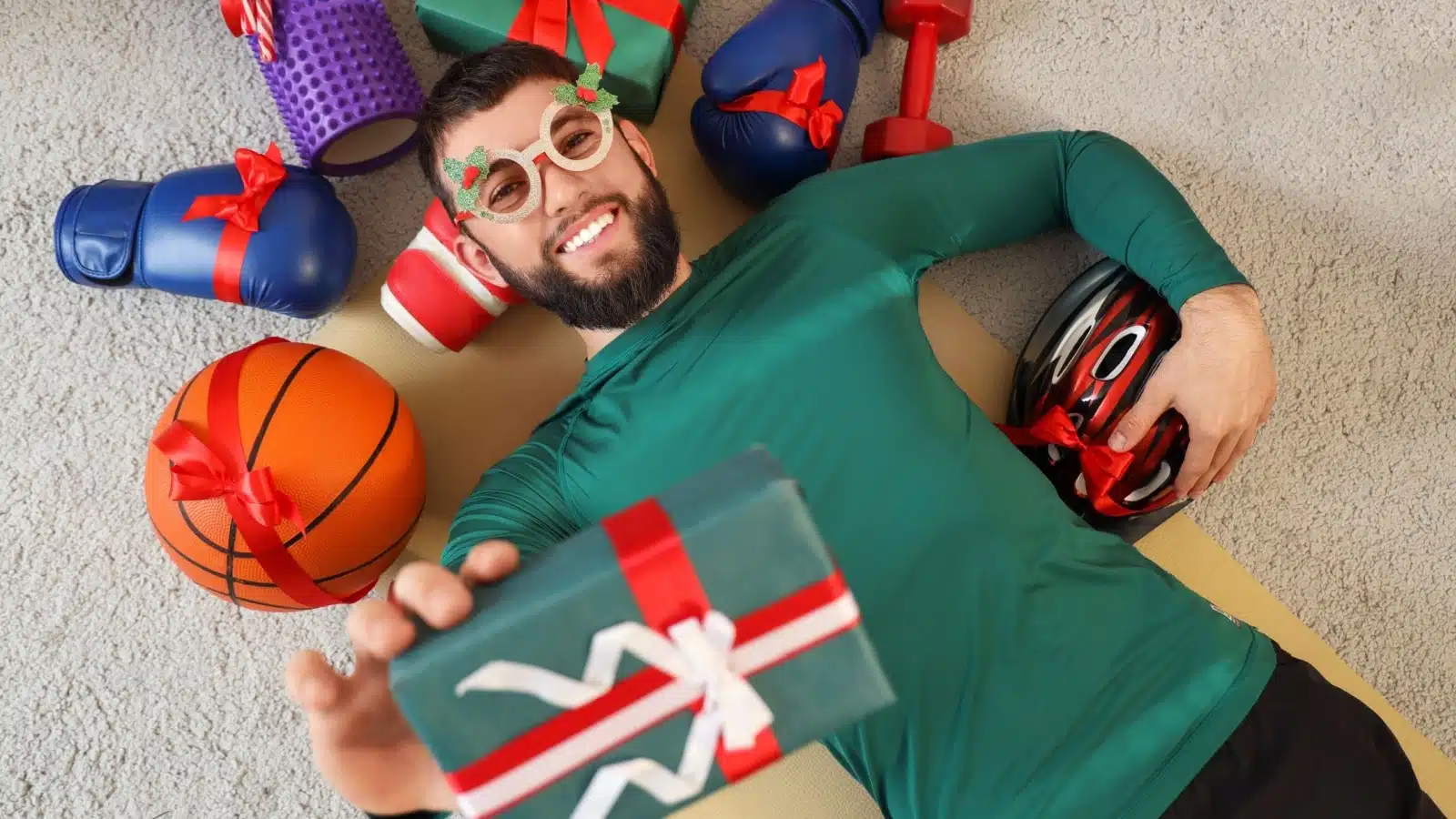 Someone who loves sports surrounded by presents for sports. 