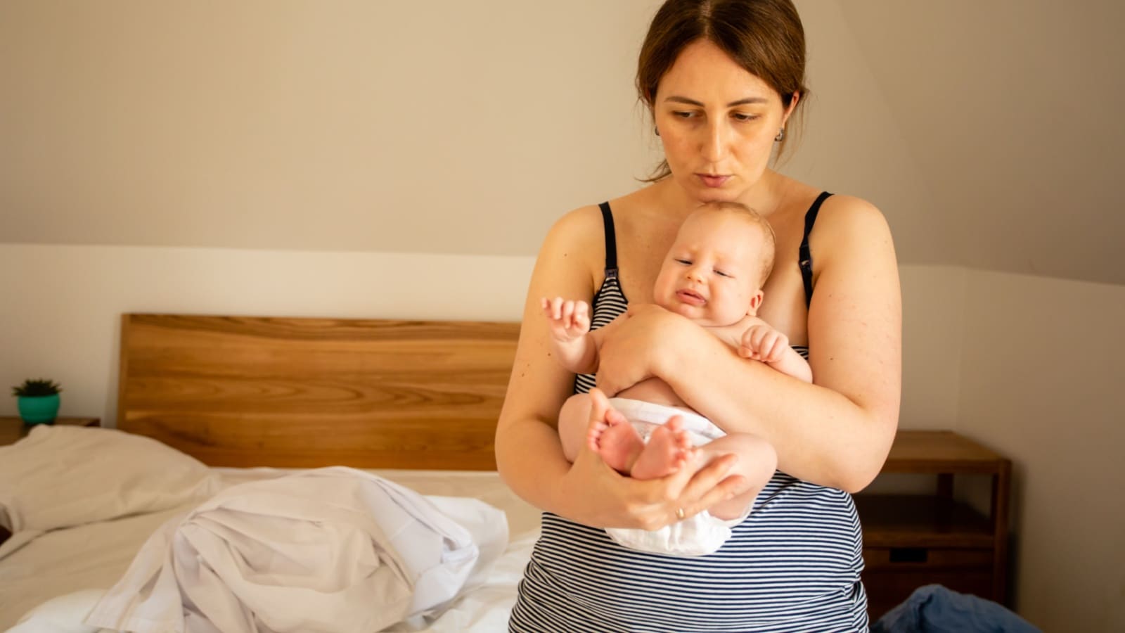 A tired mom holds her baby.