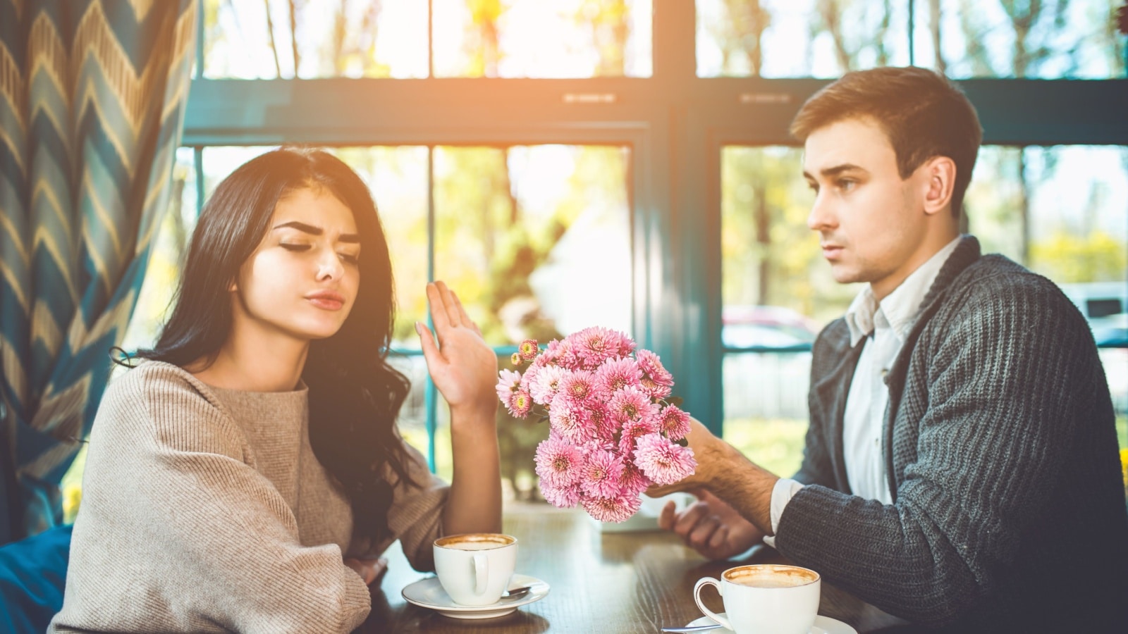 A woman rejecting her date's gift of flowers over coffee.