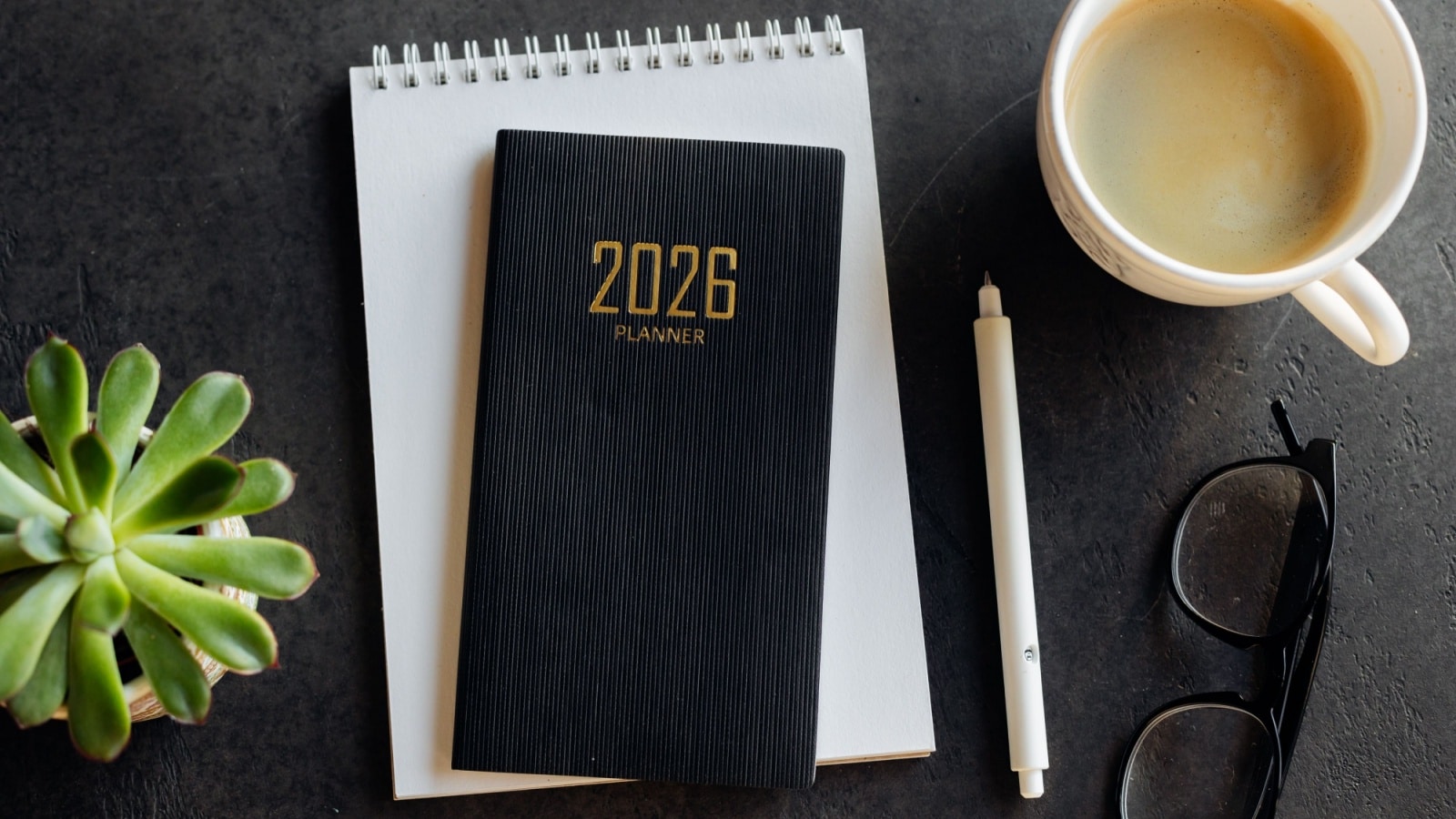 Top view of an organized desk with a 2026 planner on top to represent the best planners of 2026.