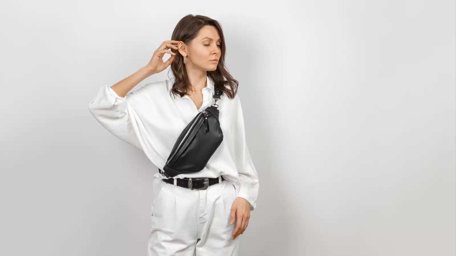 A woman wearing a purse strapped around her chest, keeping her belongings safe from pickpockets.