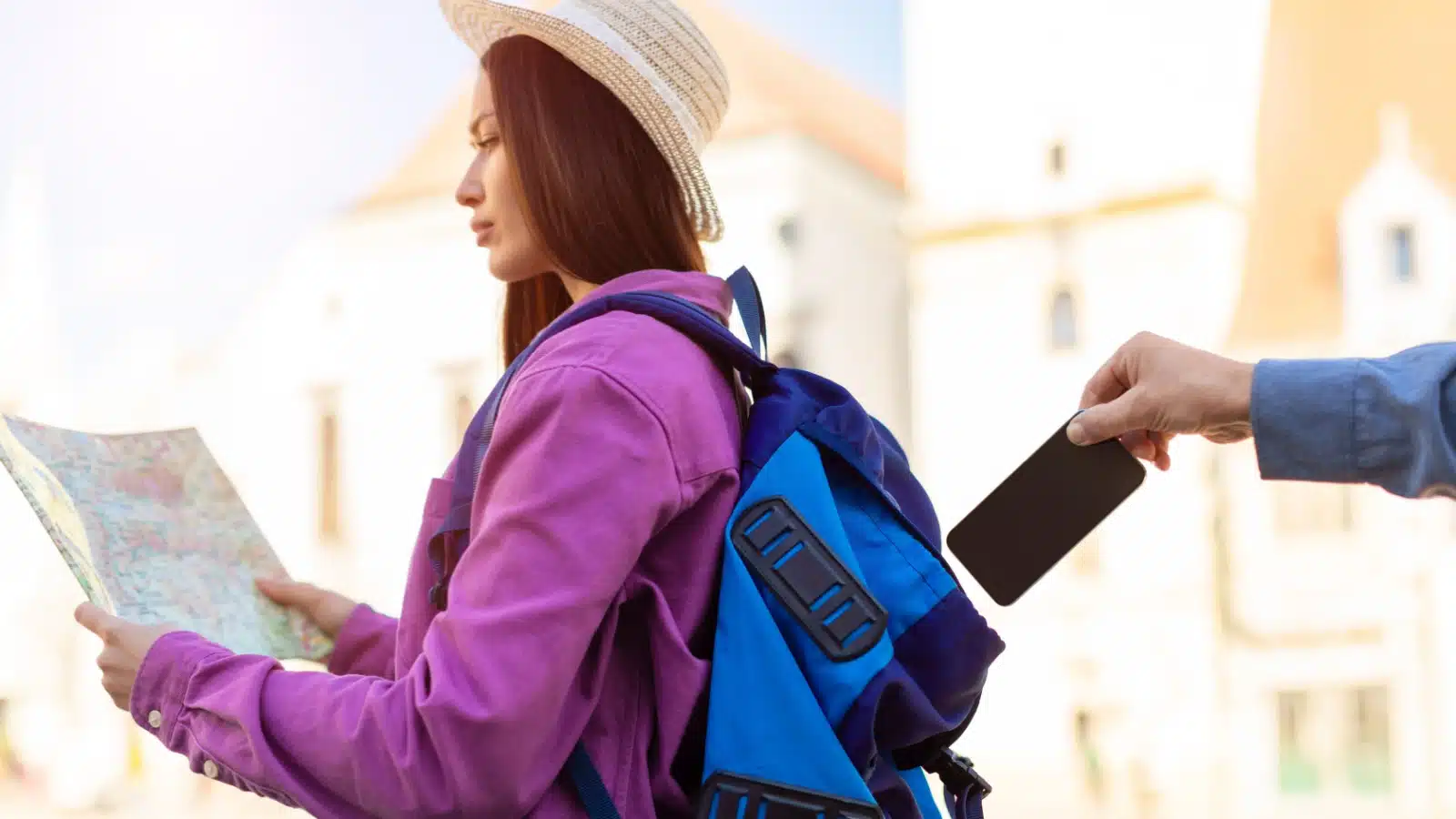 A pickpocket steals a wallet out of a tourists backpack to represent scams in Istanbul.
