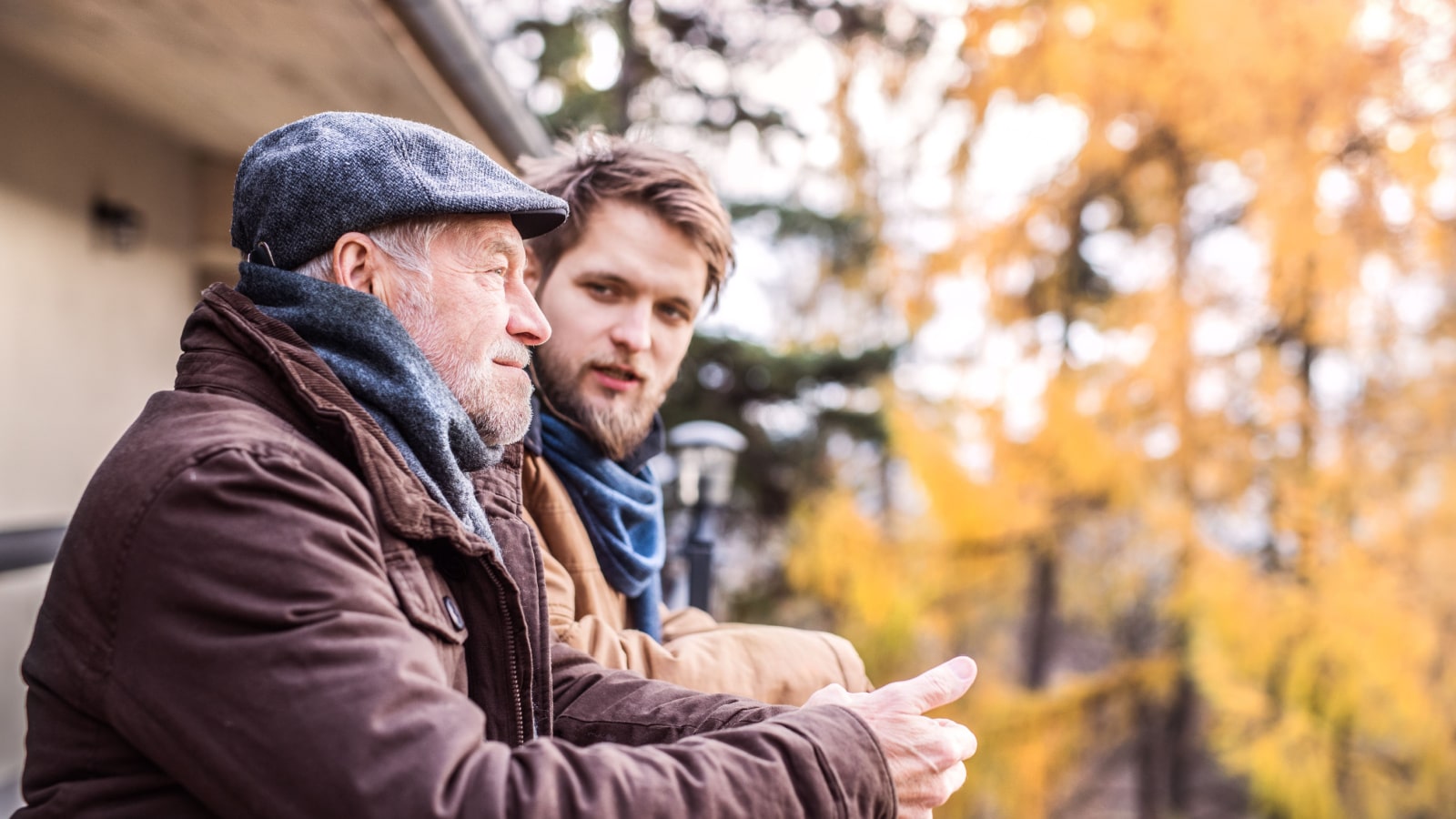 A senior man and his adult son having a chat outside.