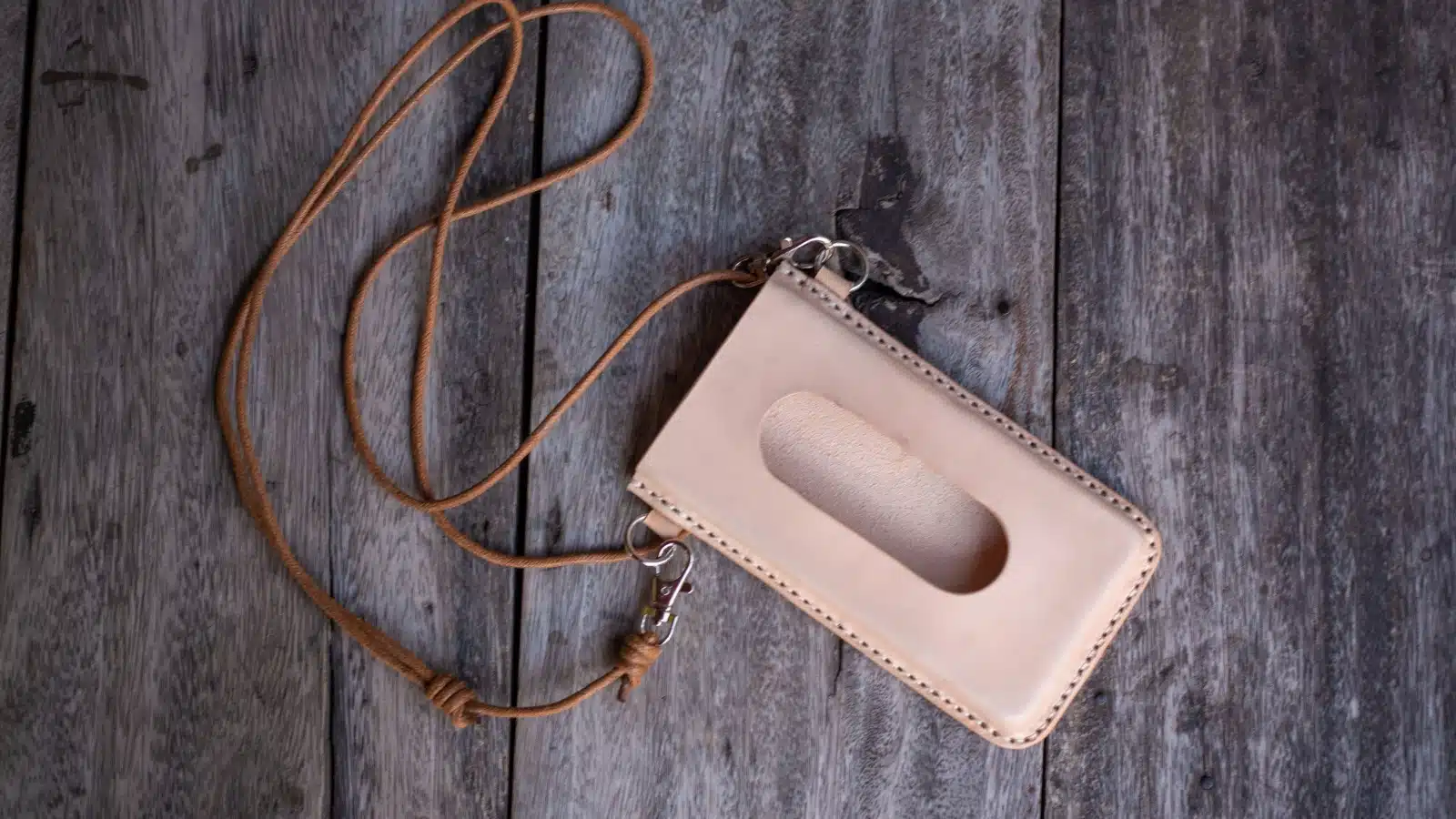 Isolated leather wearable next wallet on a wooden background.