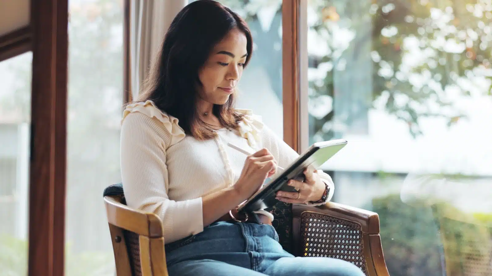 A woman uses her tablet to journal rather than traditional pen and paper.