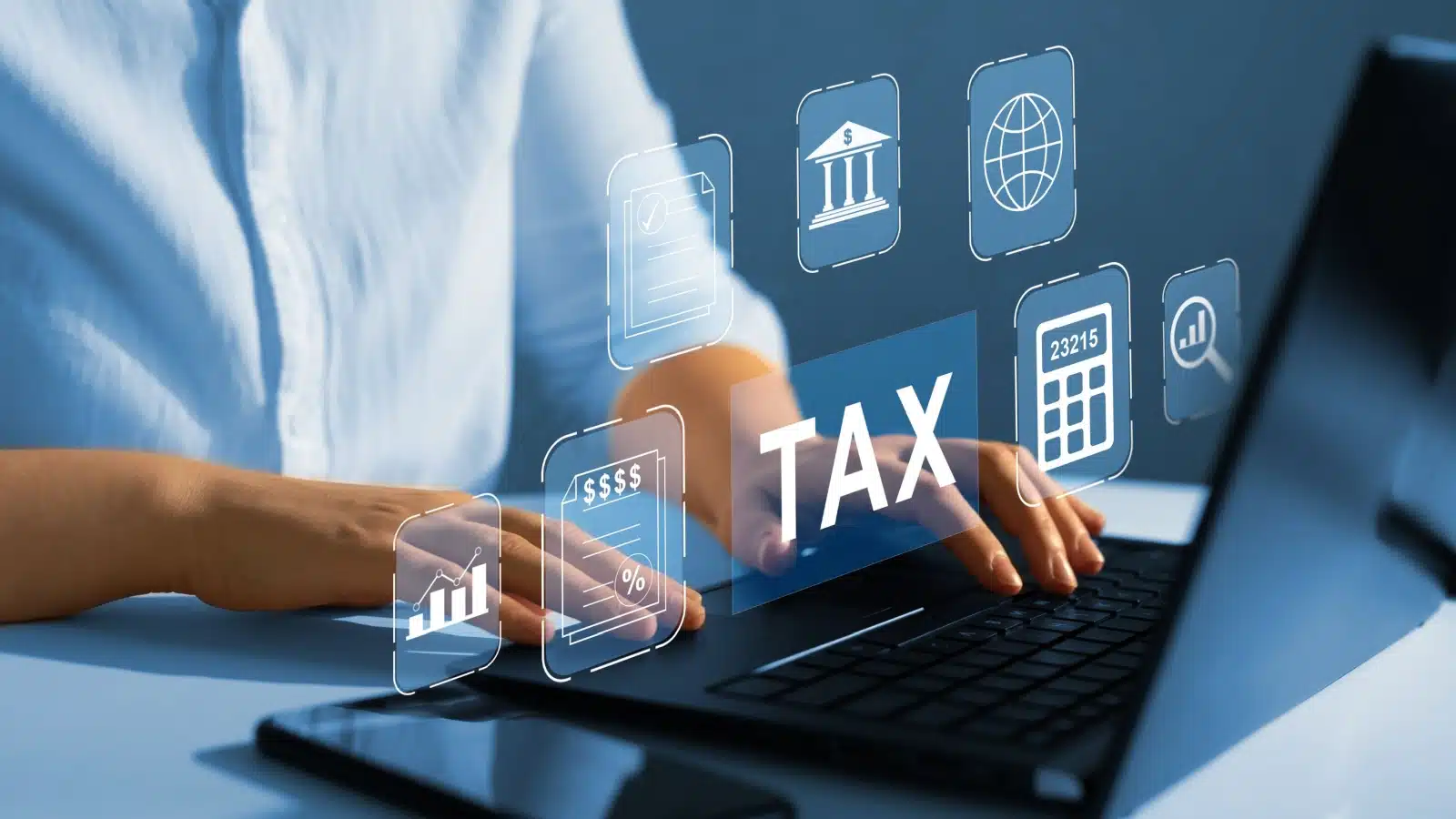 Hands use a laptop with various tax and financial icons to represent researching tax law.
