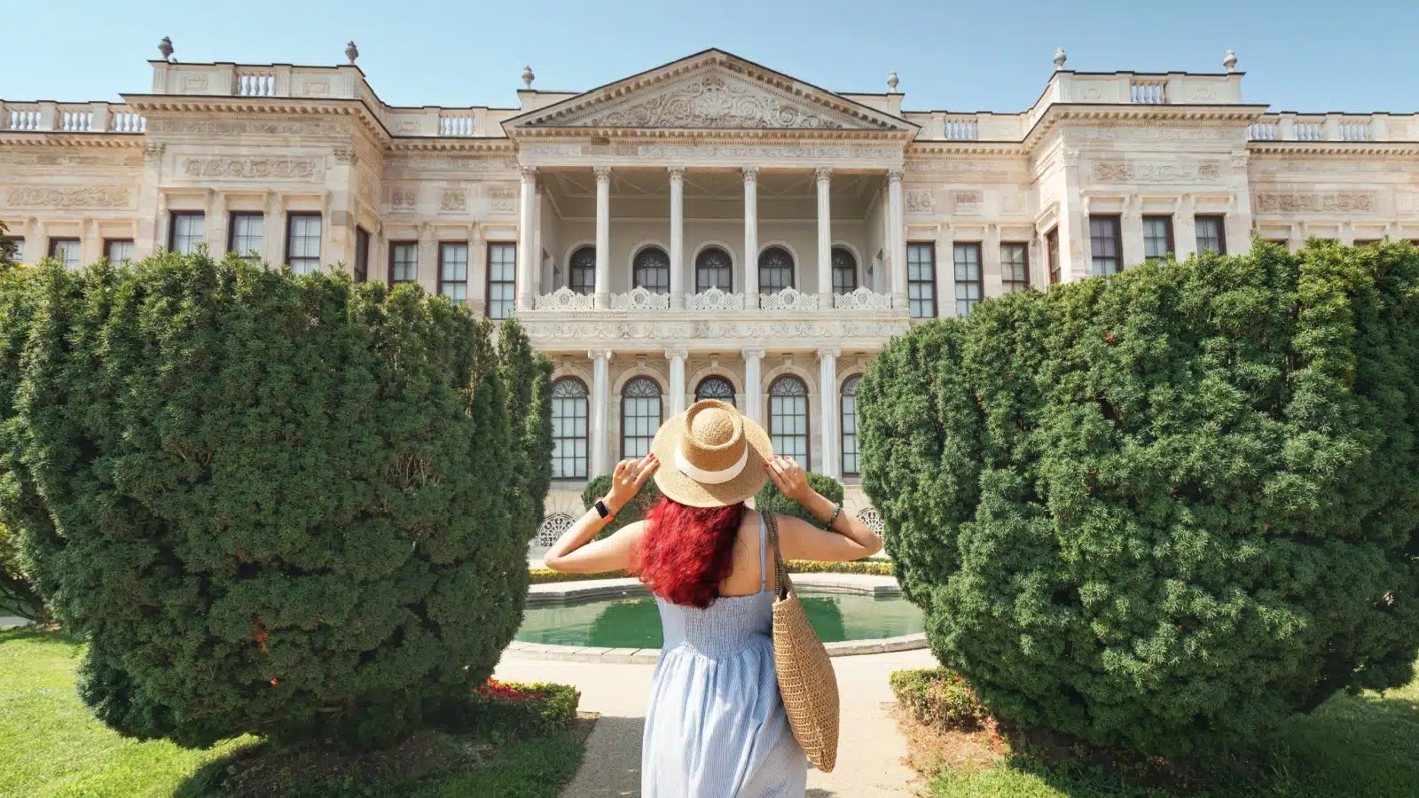 A tourist stands in front of a gorgeous palace.