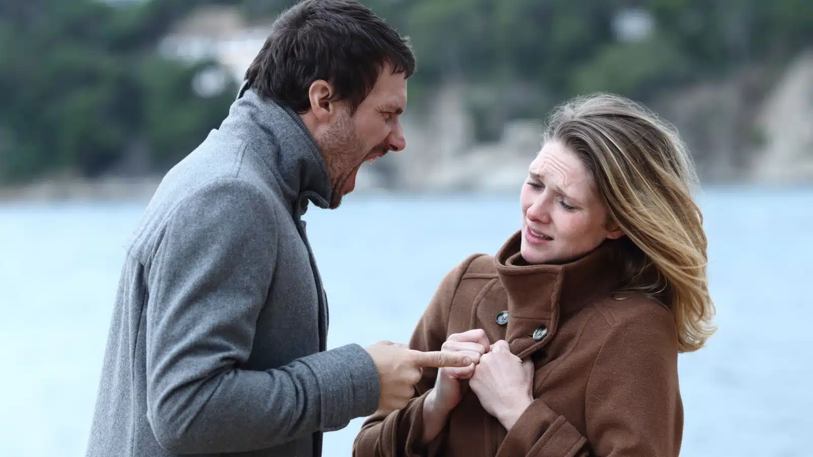 An angry man yells at a scared woman.