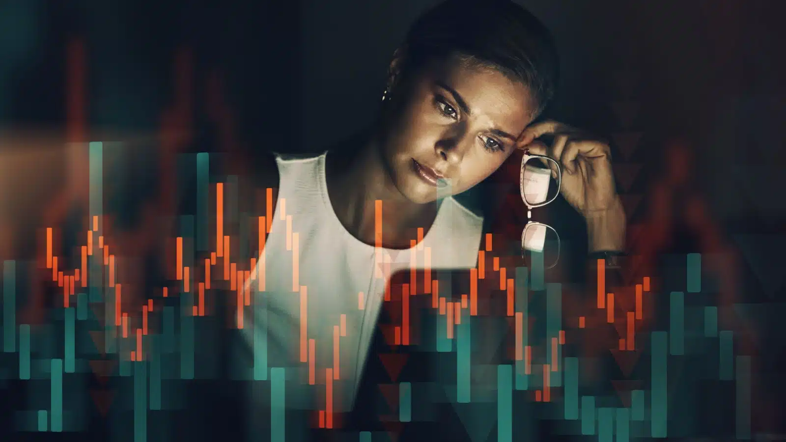 A woman looks at her computer screen, worried. A graphic of a red investment graph is overlayed in the foreground, representing a bad investment.