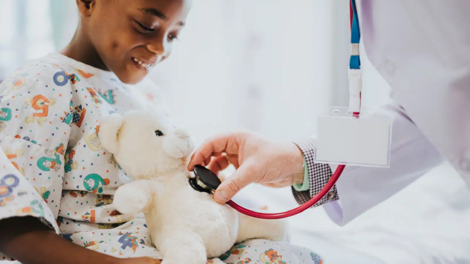 A pediatrician uses a stethoscope to check a teddy bear's heart beat at a children's hospital.