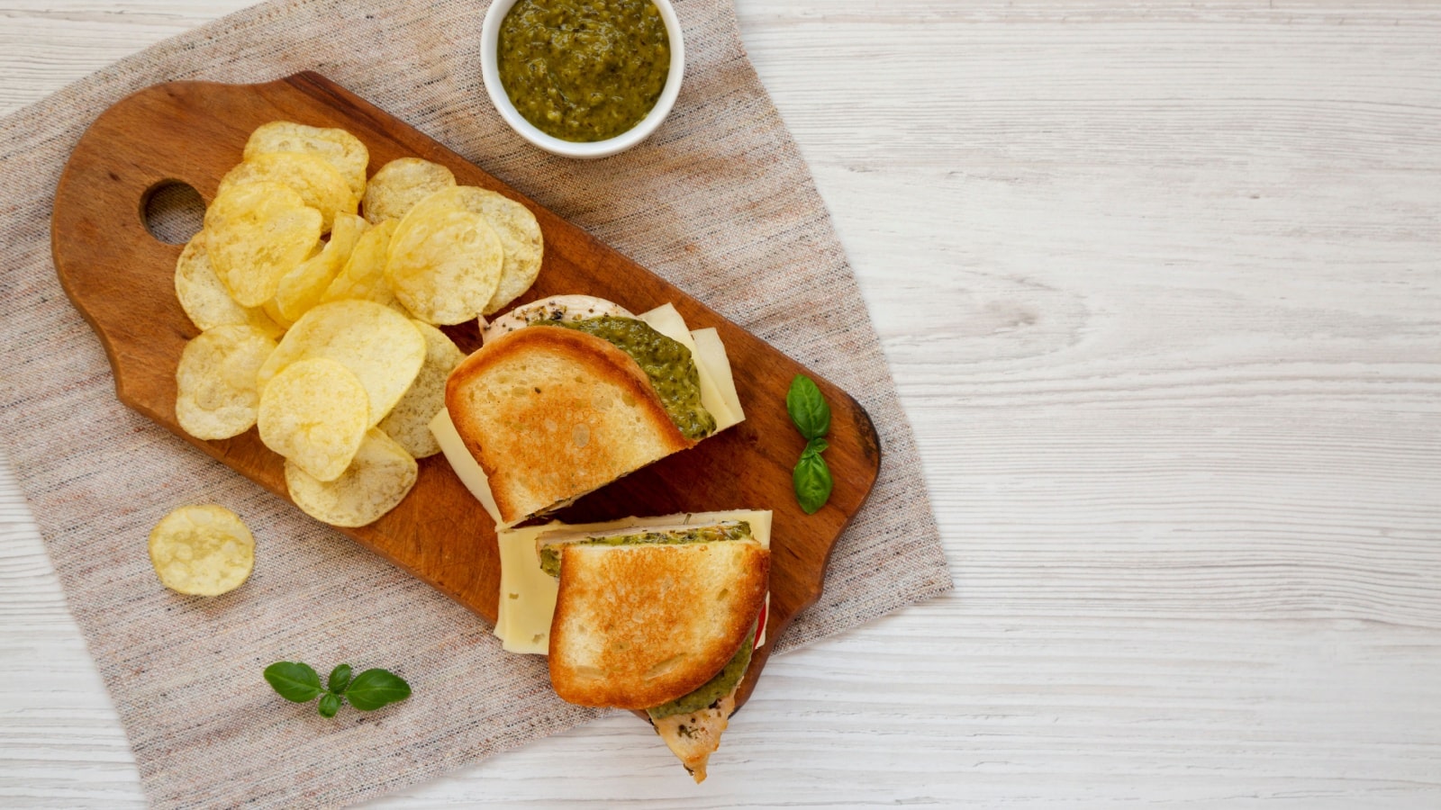A grilled sandwich with chips on a serving platter to represent the best chip pairings.