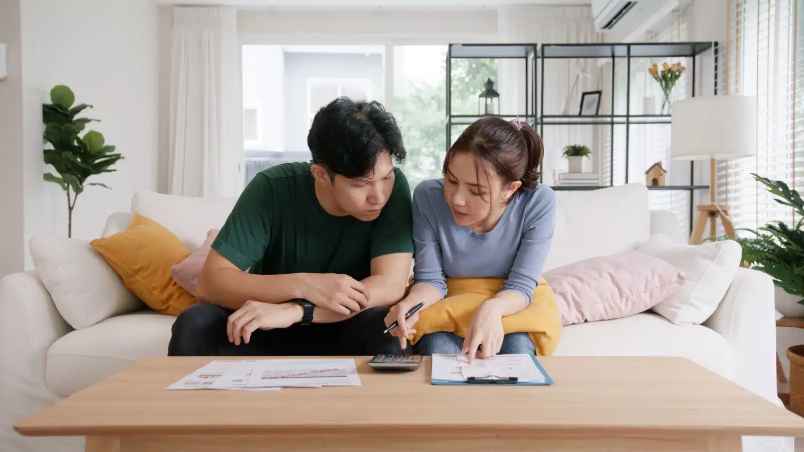 An anxious couple reviews their expensive bills. 