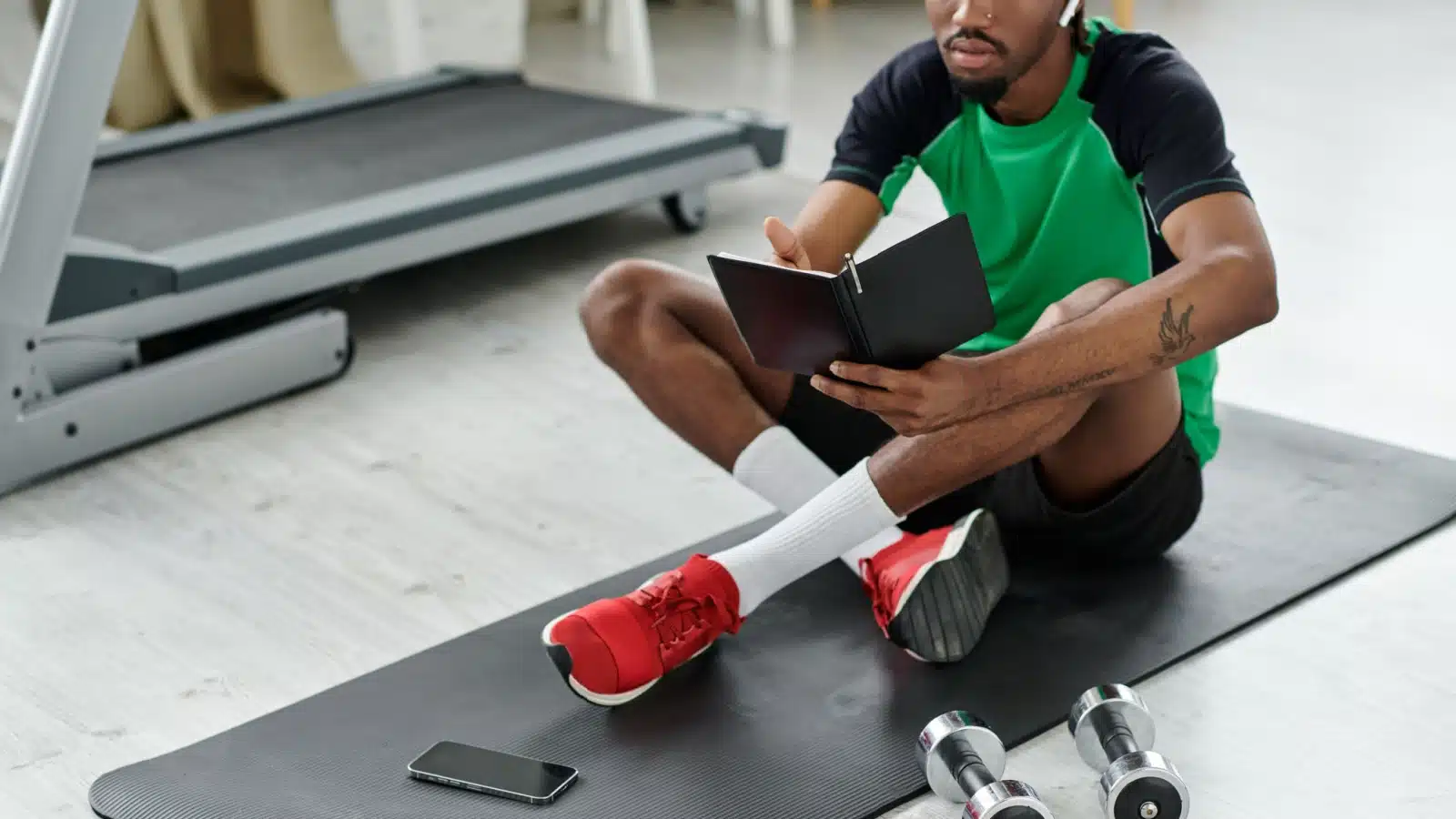 A man records his workout in a fitness journal.