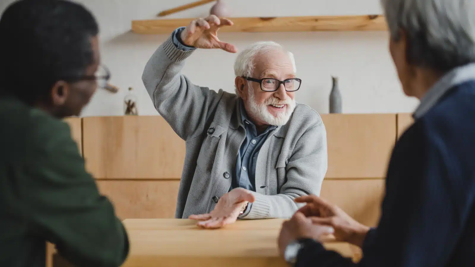 A man gestures while sharing a story with his friends.