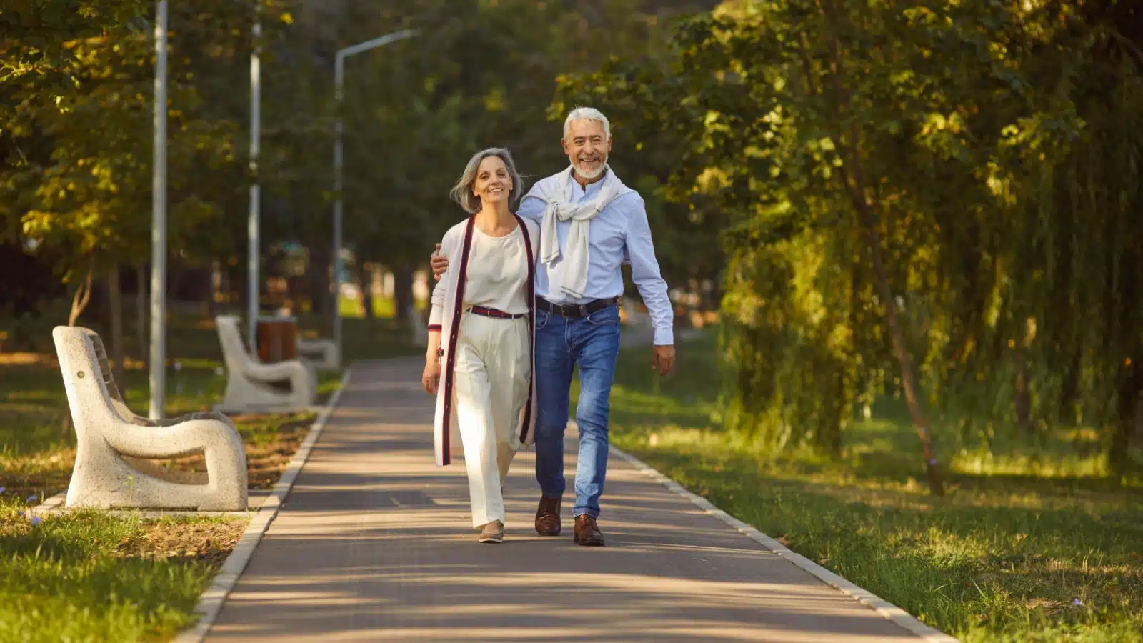 A happy senior couple takes a stroll in a park.