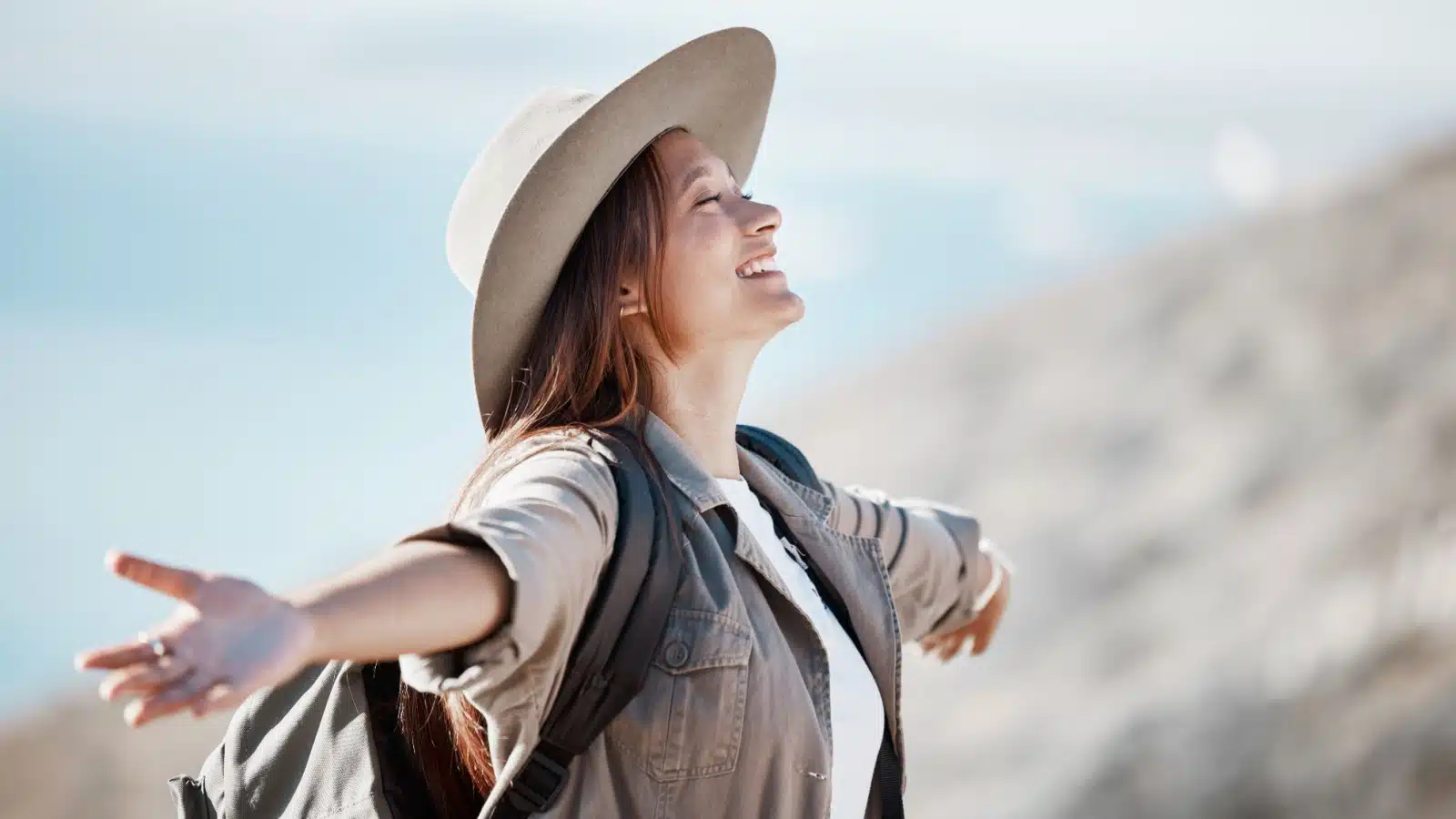 A happy woman spreads her arms in joy as if she just achieved one of her life goals.