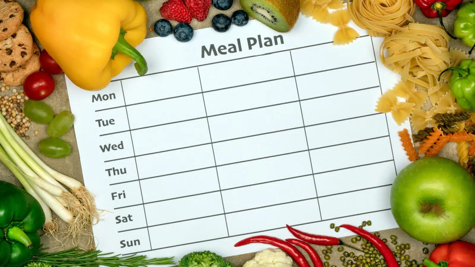 A blank meal plan surrounded by vegetables.
