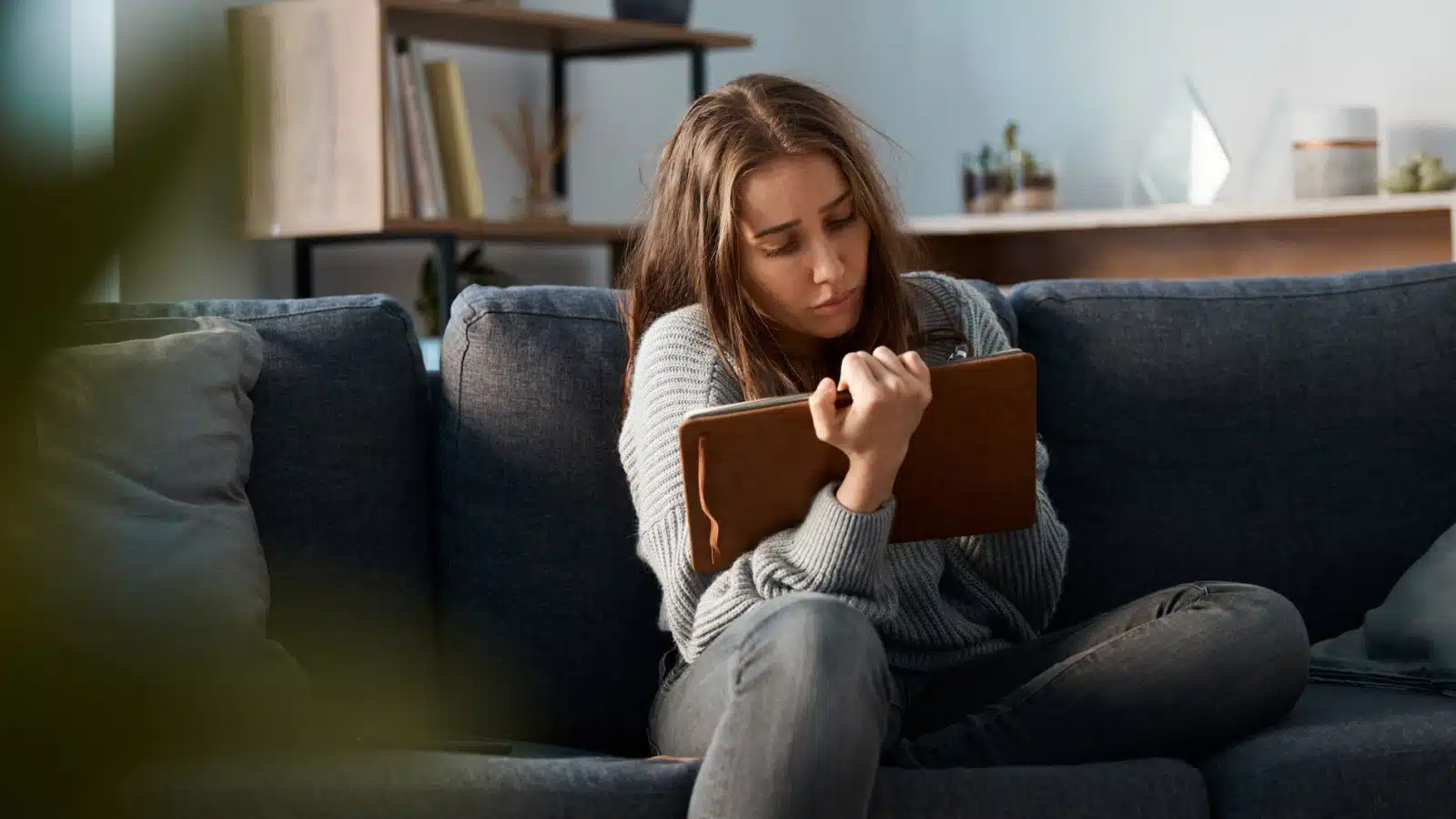 A sad woman writes in her journal.