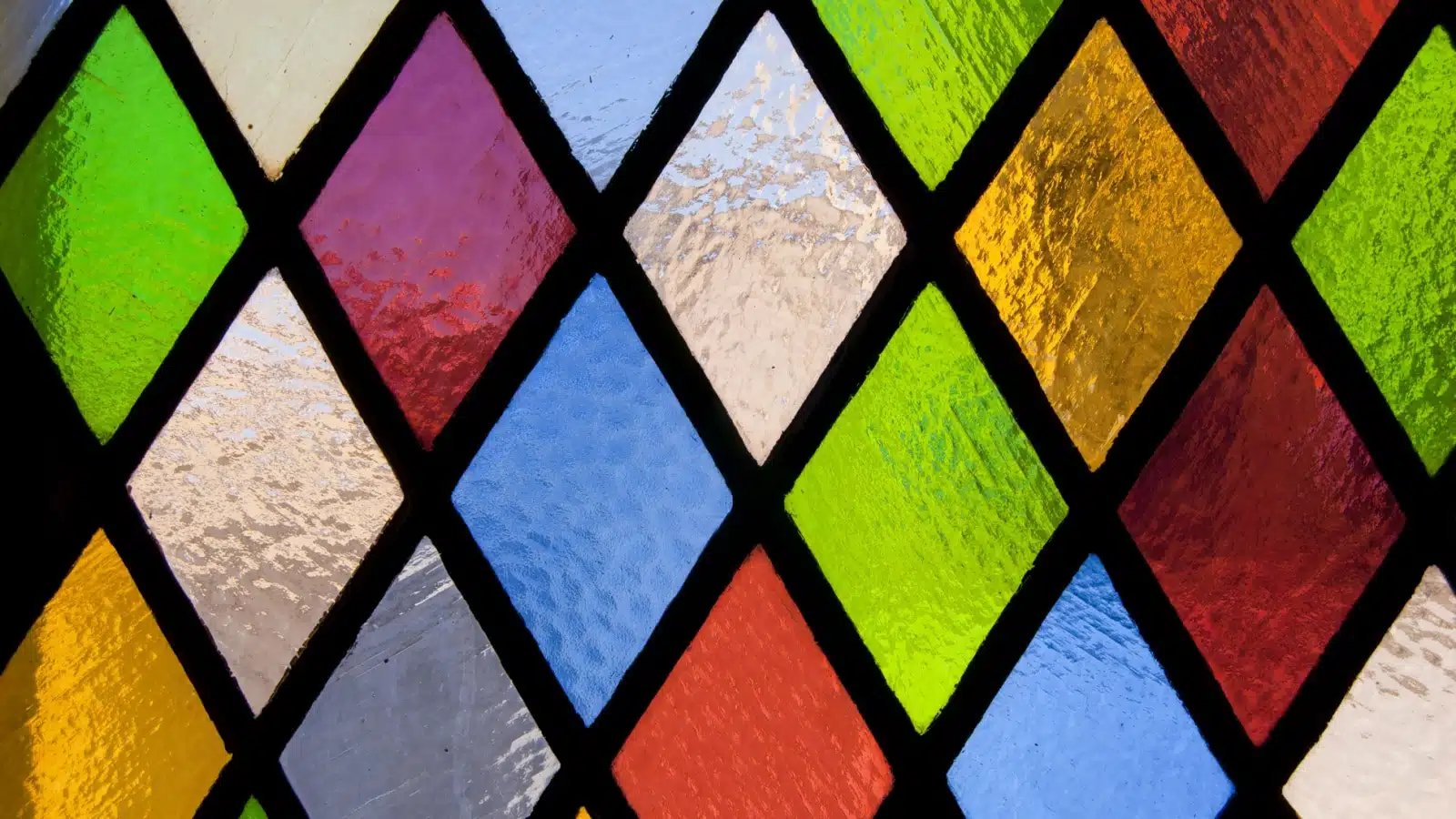 A stained glass window with diamonds of different colors.