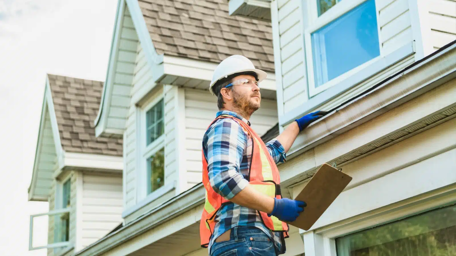 A man in a hardhat inspecting a home for safety.