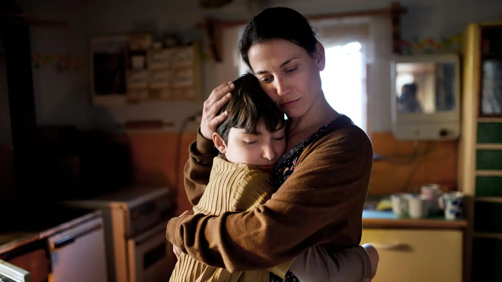 A sad mom hugs her child. 