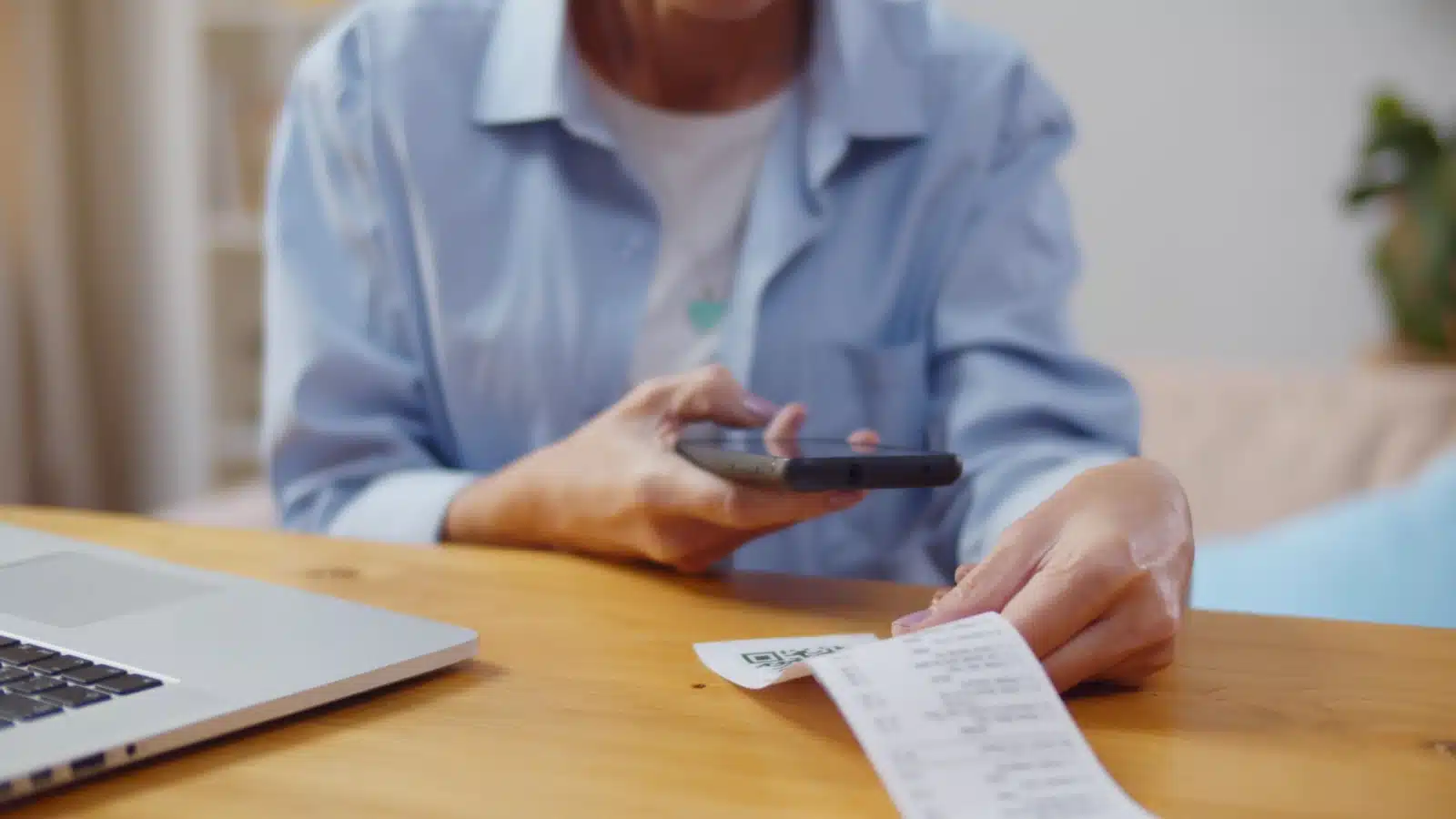 A woman scans a physical receipt with her cell phone to get cash back.