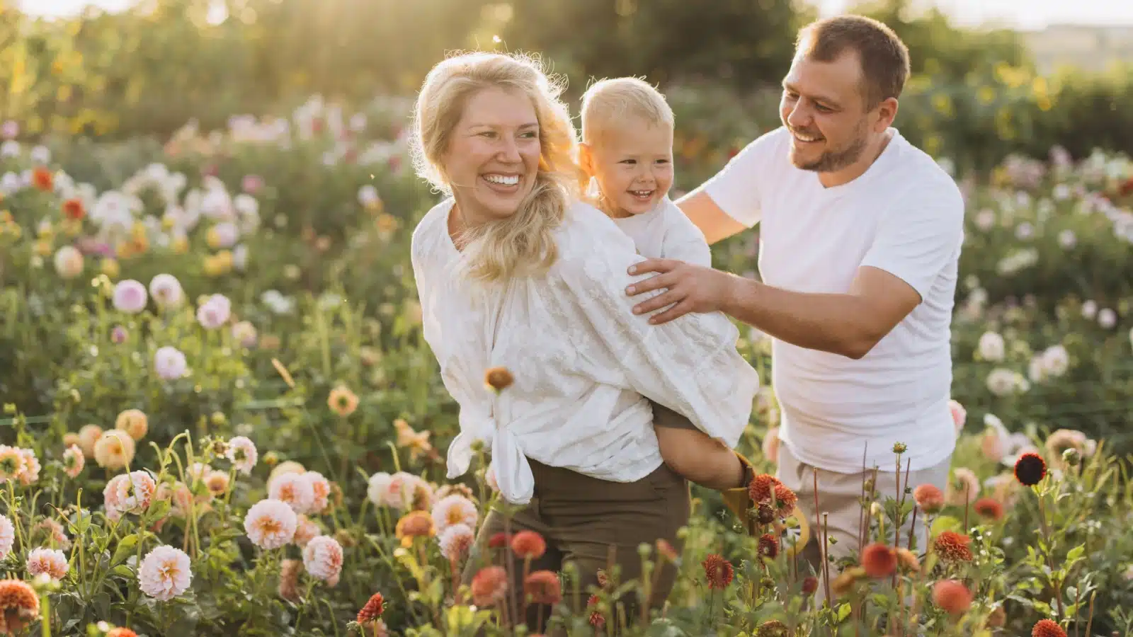 A family enjoys a walk through wildflowers growing in the spring.