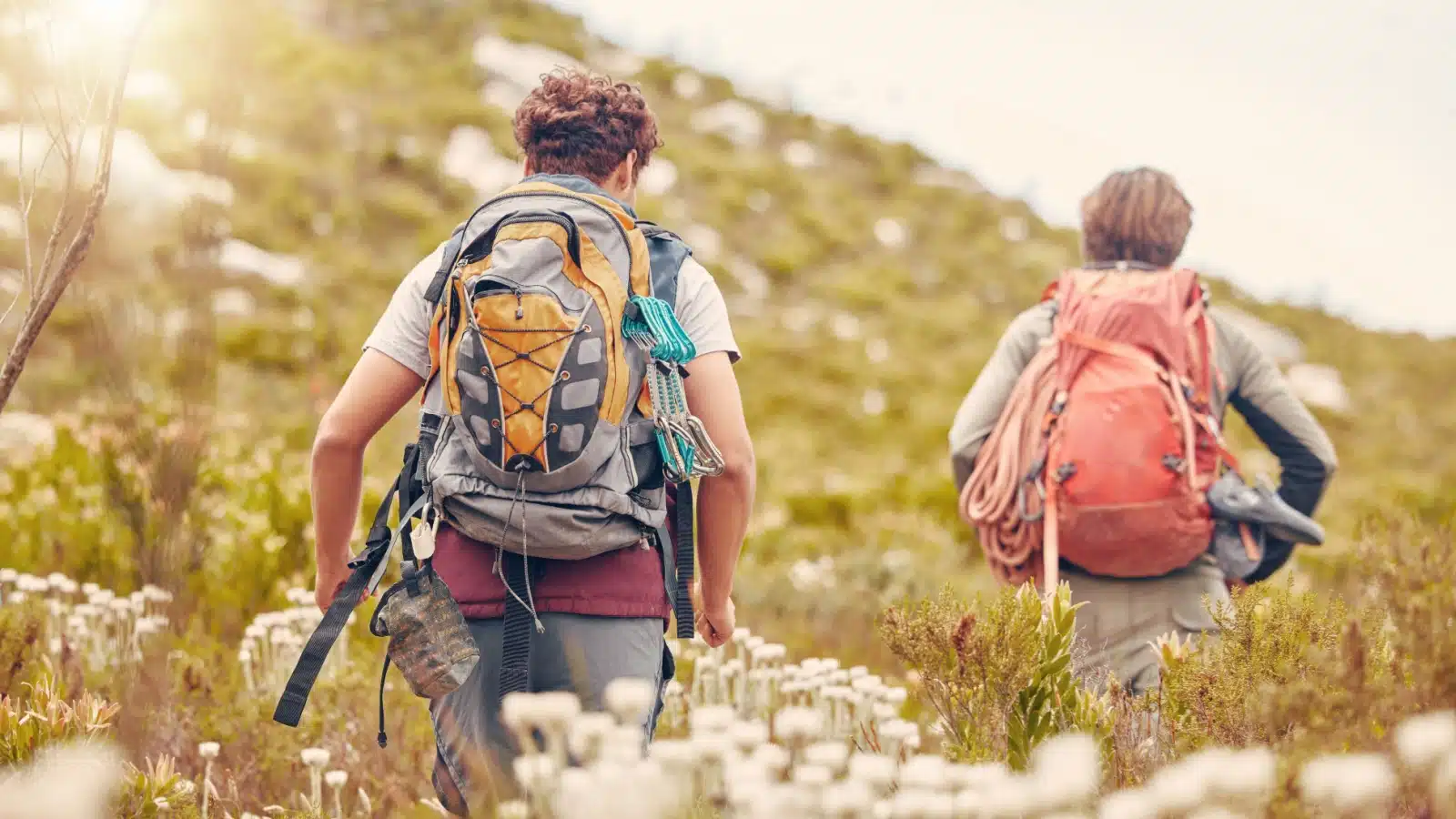 Two people enjoy a spring hike where flowers are blooming.