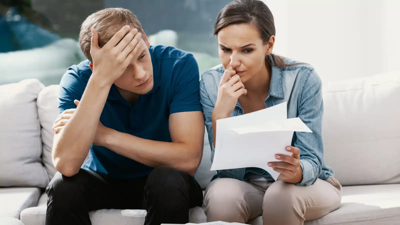 A stressed couple looks at their bills, wondering how they will pay. The image represents how vital money is to our lives.