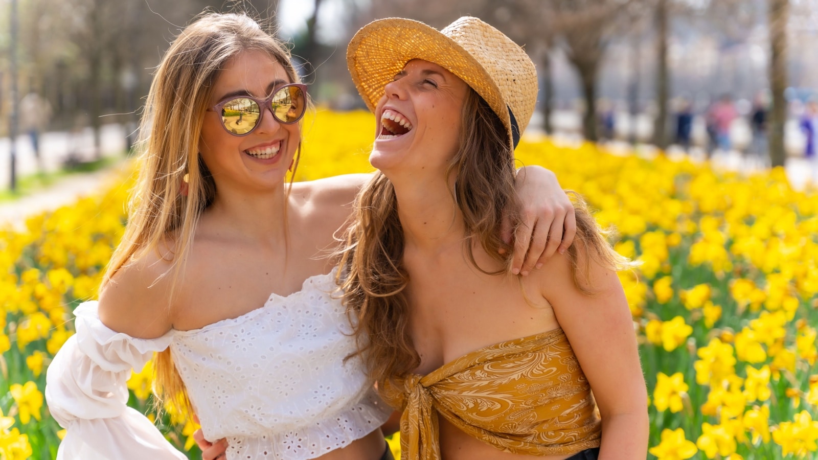Tow happy friends enjoying a flower garden to represent things to do in Spring with friends.