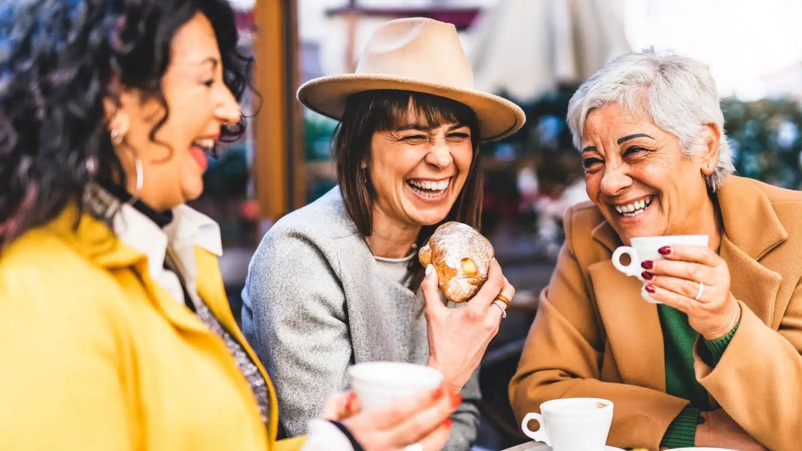 Three older women enjoy brunch and coffee together.