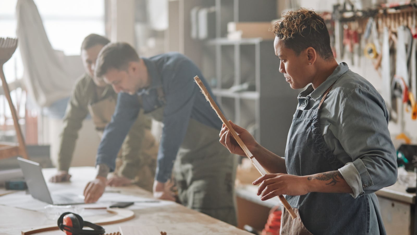 A group at a work bench making wood projects.