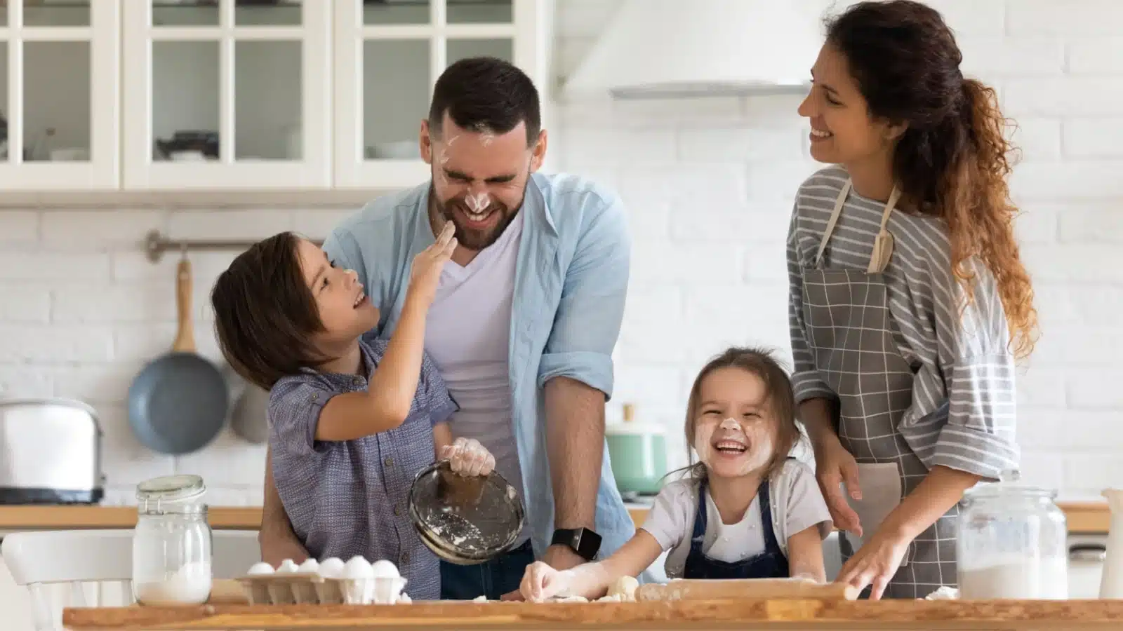 A family of four enjoys baking together.