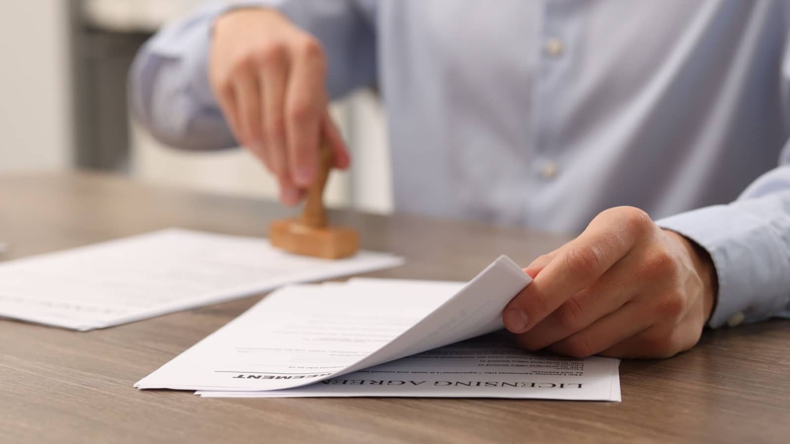A man stamps approval for a regulatory document. 