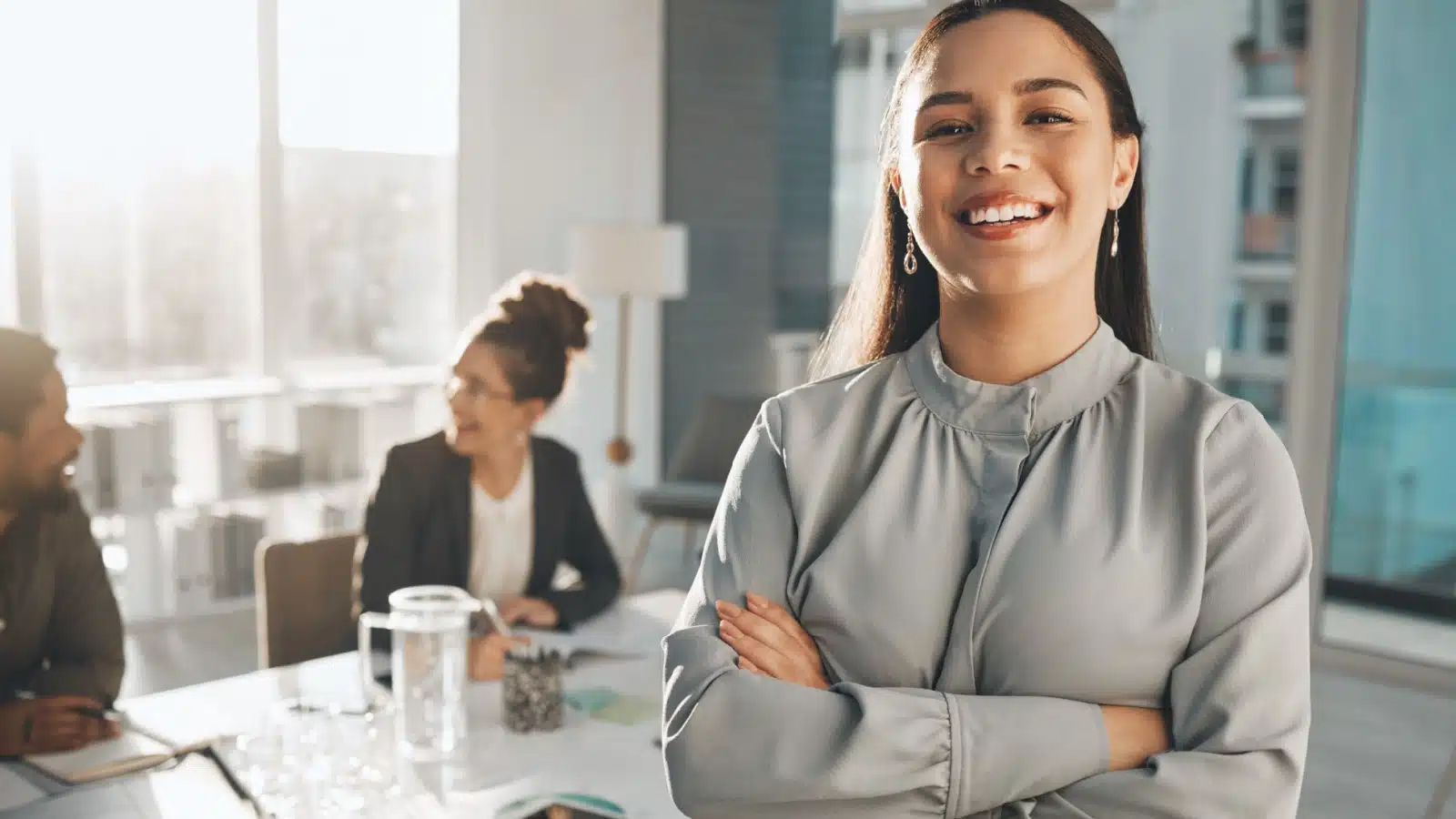 Portrait of a proud woman standing in front of a meeting room at work.