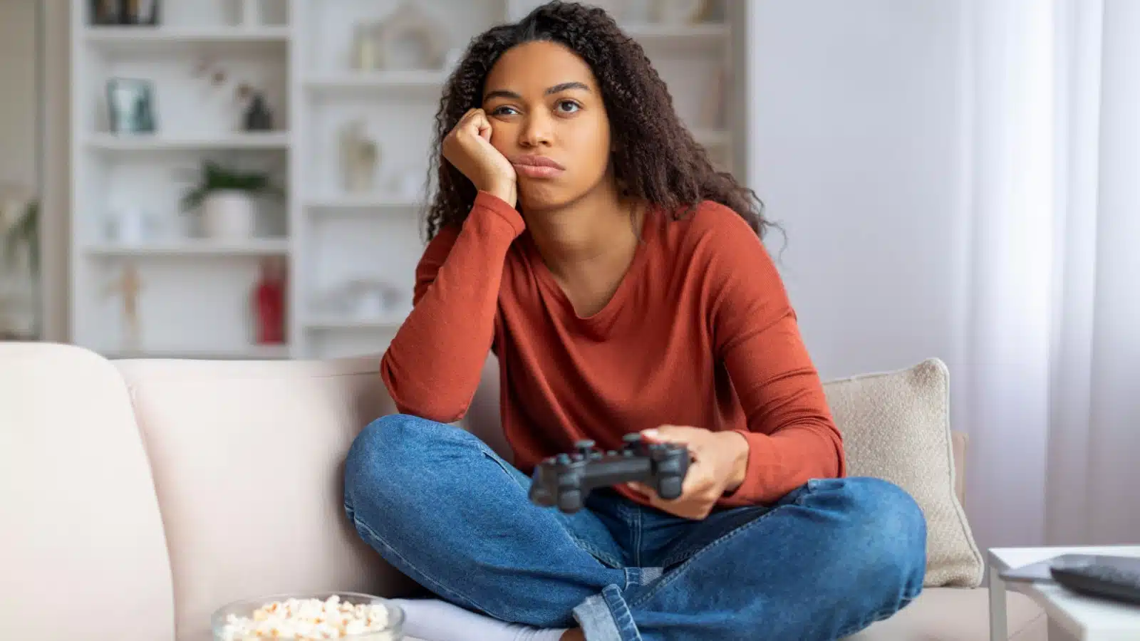 A bored woman holding a gaming control to represent the worst video games.