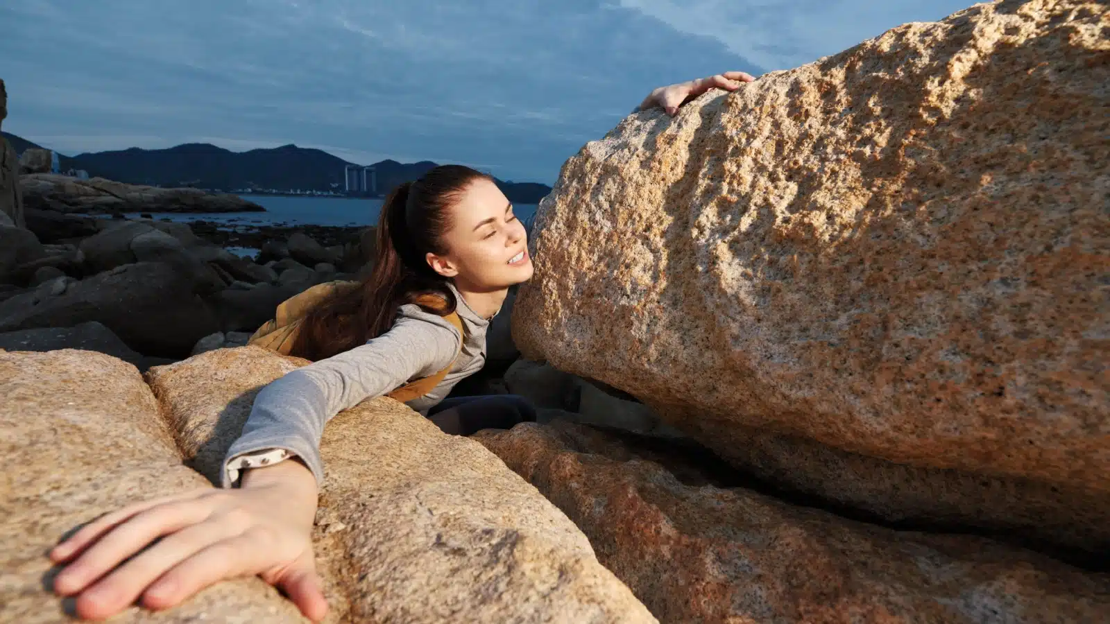 A woman challenges herself during a hard climb.