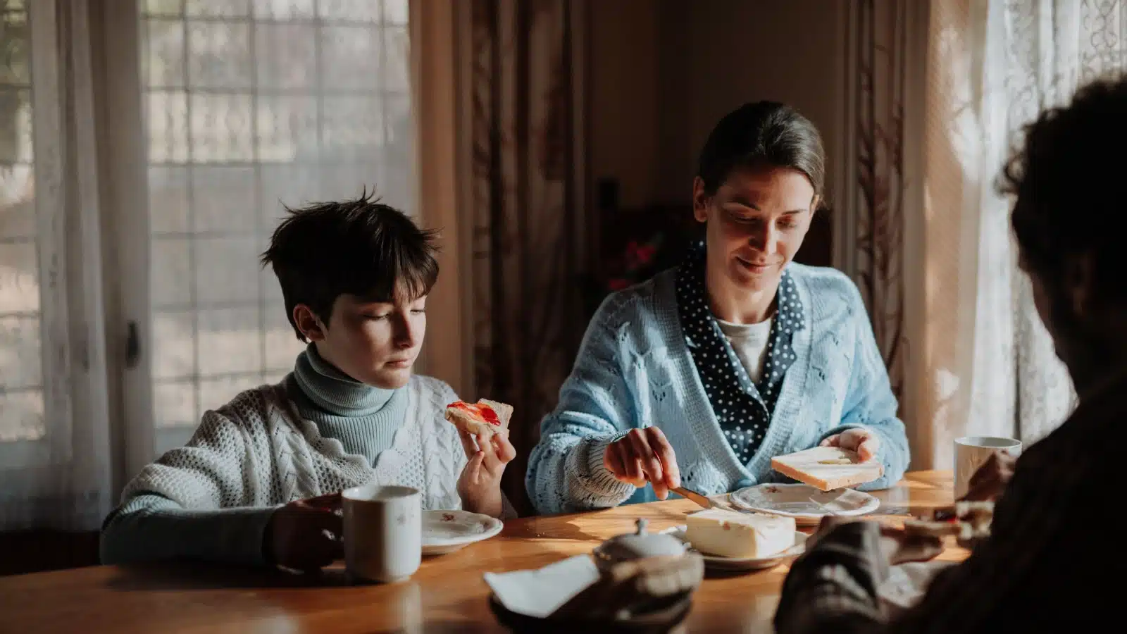 A family eats a small breakfast of bread, cheese and jam to represent food insecurity.
