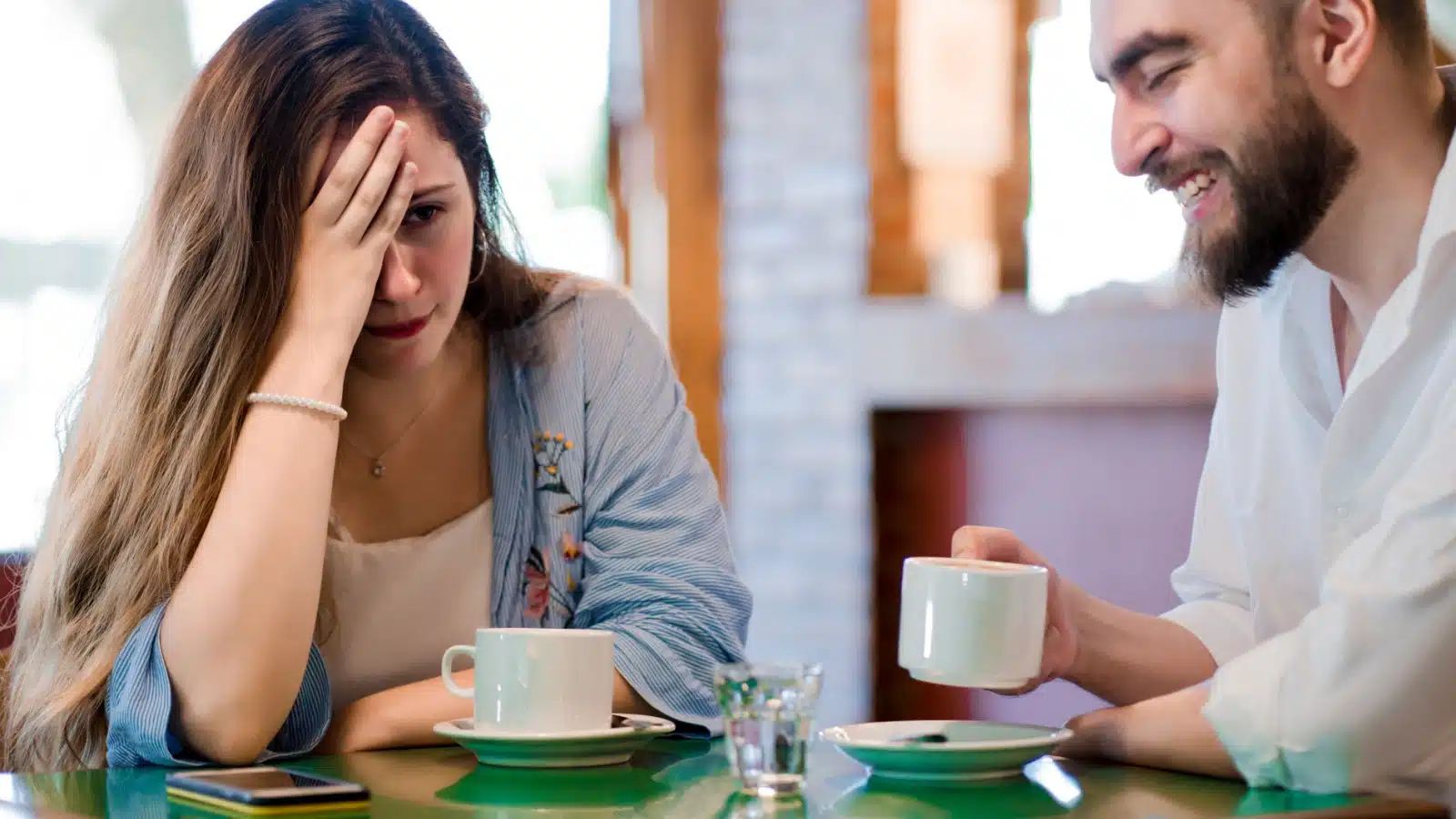 A woman looks uncomfortable on a date to represent negging.
