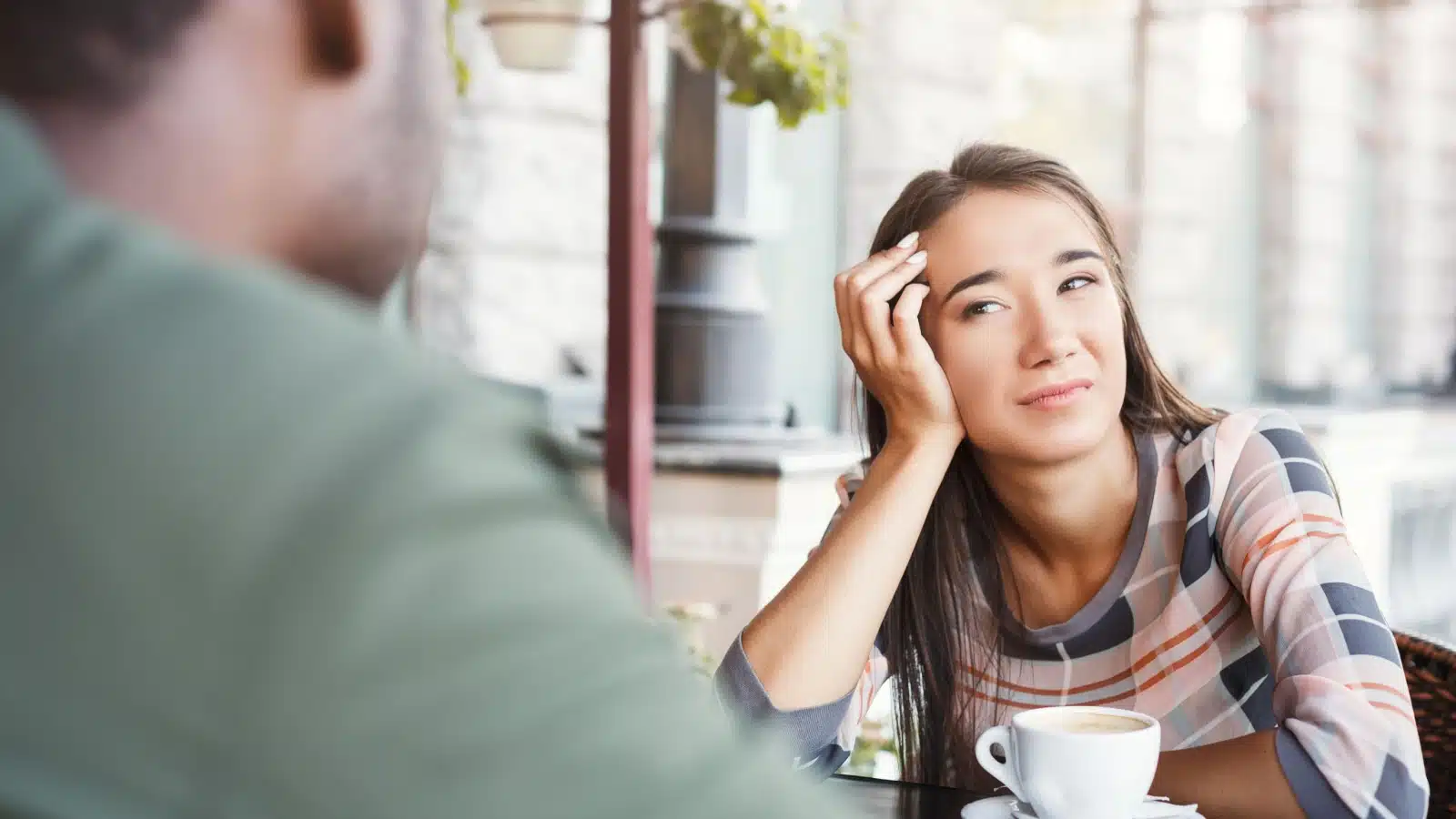 A bored woman looks at her date, hoping it will end soon to represent things that turn women off.