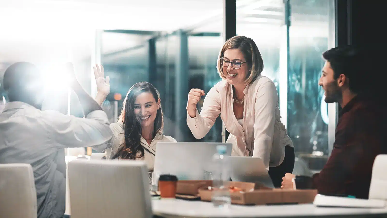 A team of business professionals celebrate after achieving a difficult goal.