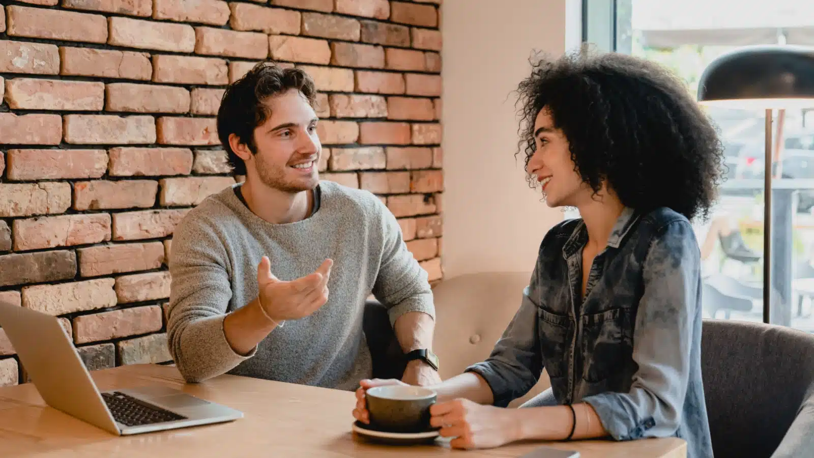 A couple on a coffee date sits together having a serious conversation.
