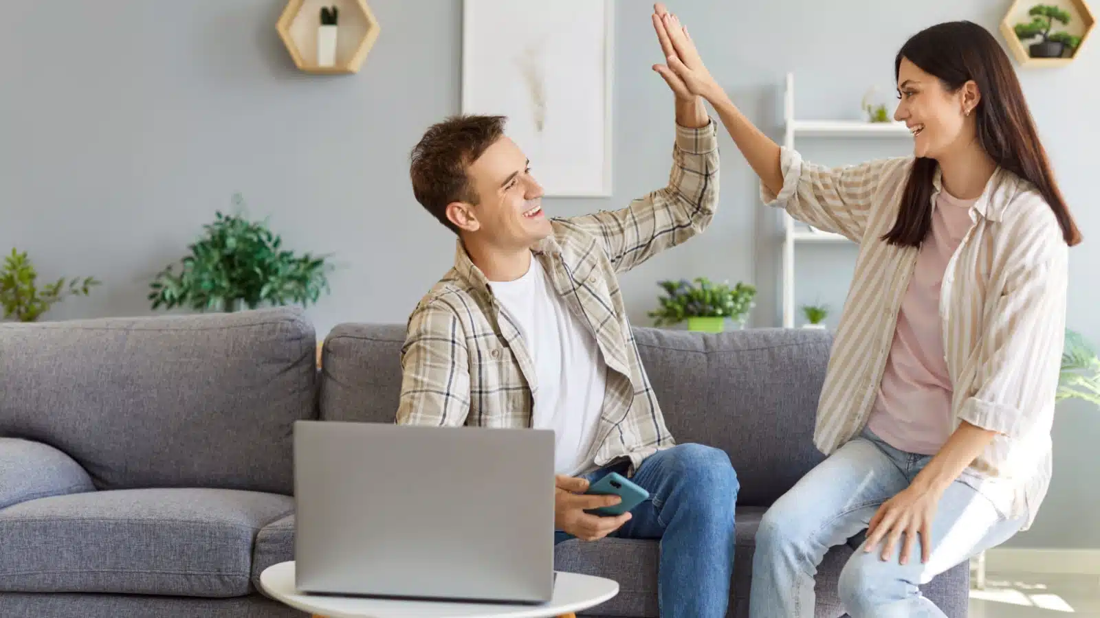 A happy couple high fives as they make a smart financial decision.