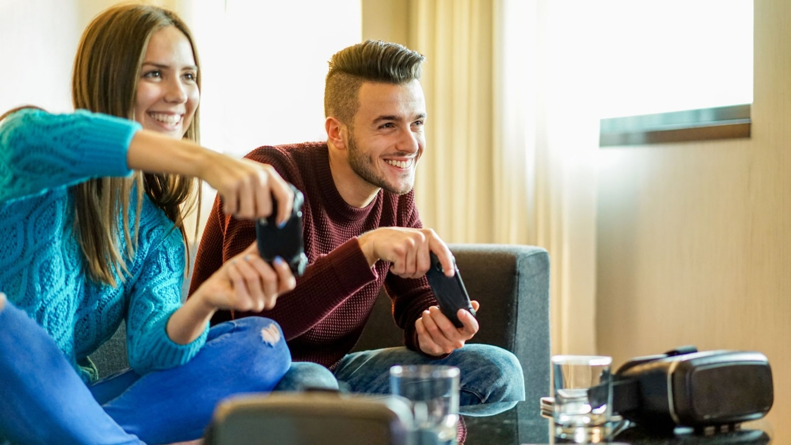 A man and a woman on the couch gaming together to represent when my girlfriend plays games with other guys.
