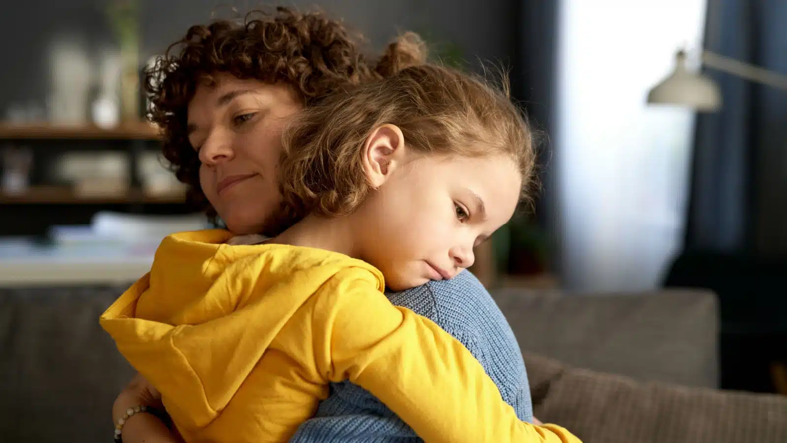 A sad single mother hugging her daughter.