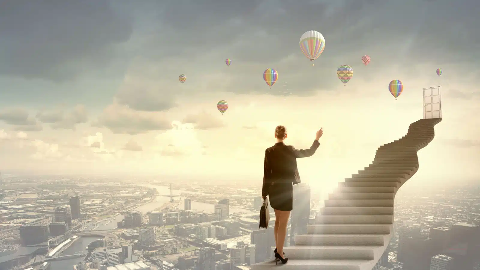 Dreamlike image of a woman walking up a massive staircase floating over a city to the white door at the end. The image represents dreaming about success.